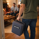 Person holding a gray 'BEVAGE' case in a social setting with people sitting at a table.